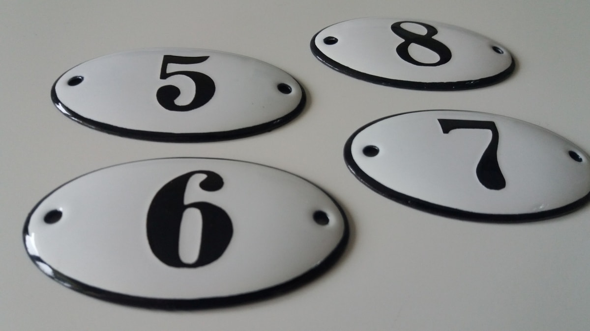 Owalne tabliczki z numerami mieszkań kamienic emaliowane